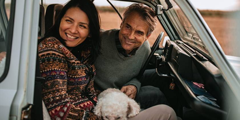 Man, woman and dog sitting in car