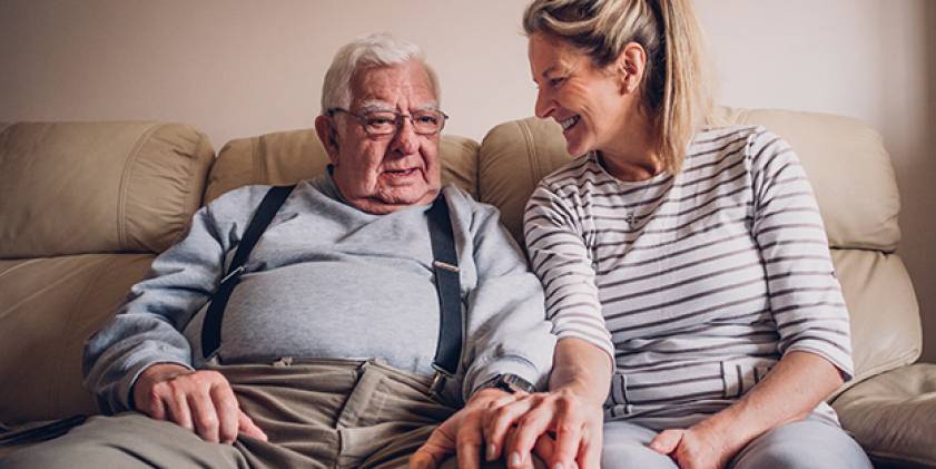 Older man with woman on sofa smiling