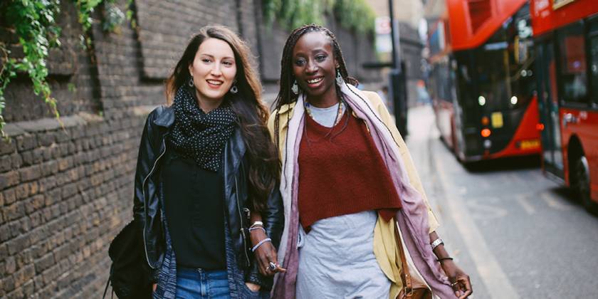 Dwy fenyw ifanc yn cerdded a sgwrsio