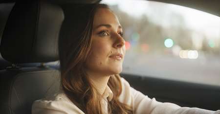Woman seen from behind walking towards a car