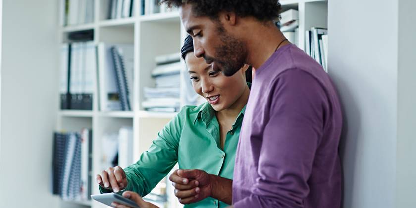 Man and woman in house looking at mobile