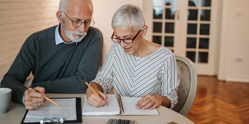 Senior couple looking at their budget together at home