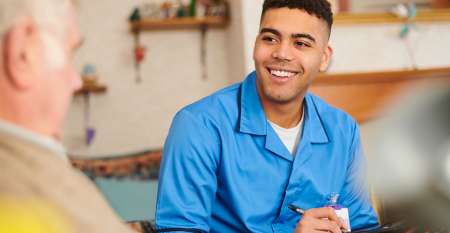 Young man writing and talking to older man