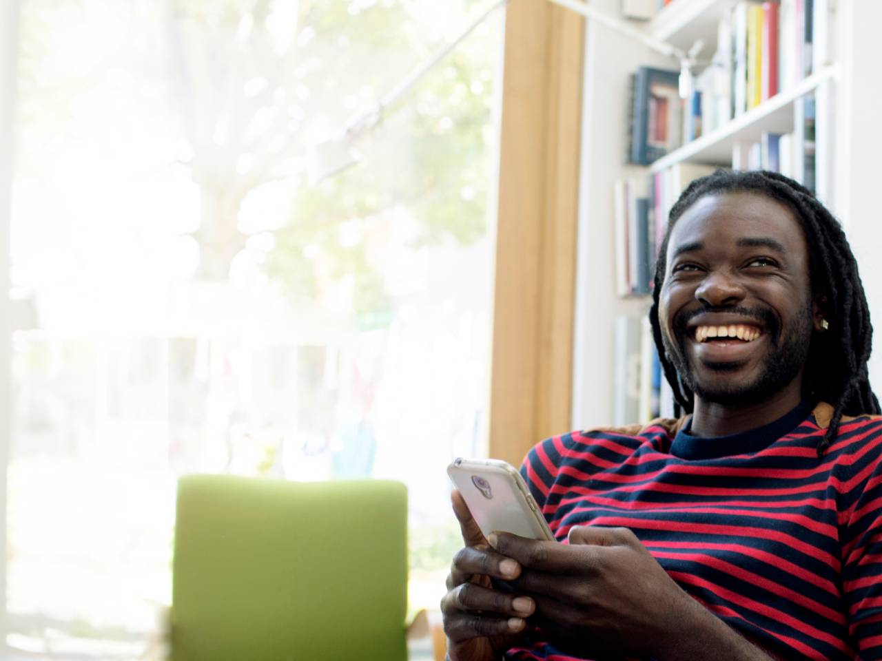 Man holding mobile laughing